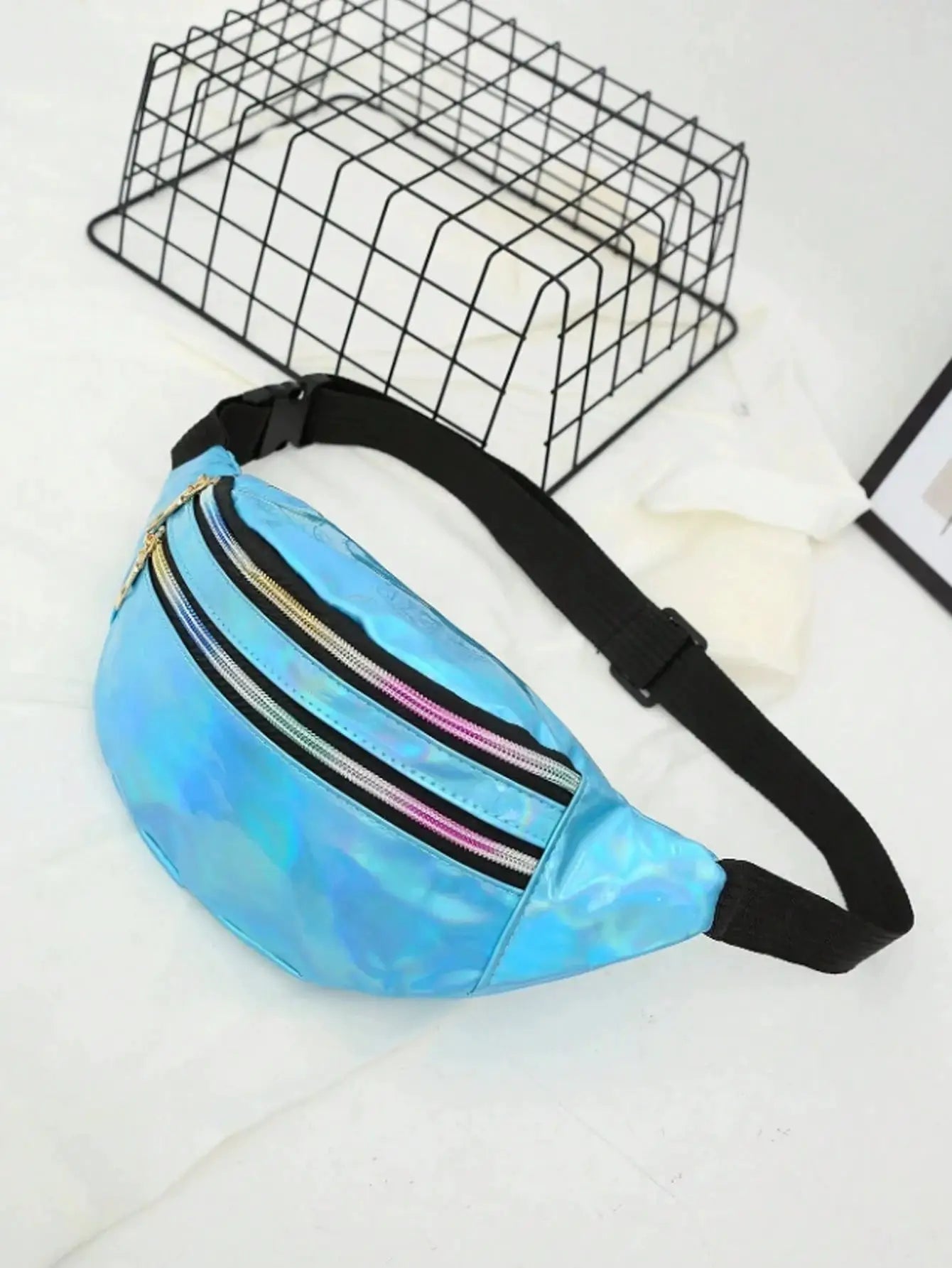Holographic blue waist bag with rainbow zippers and black adjustable strap
