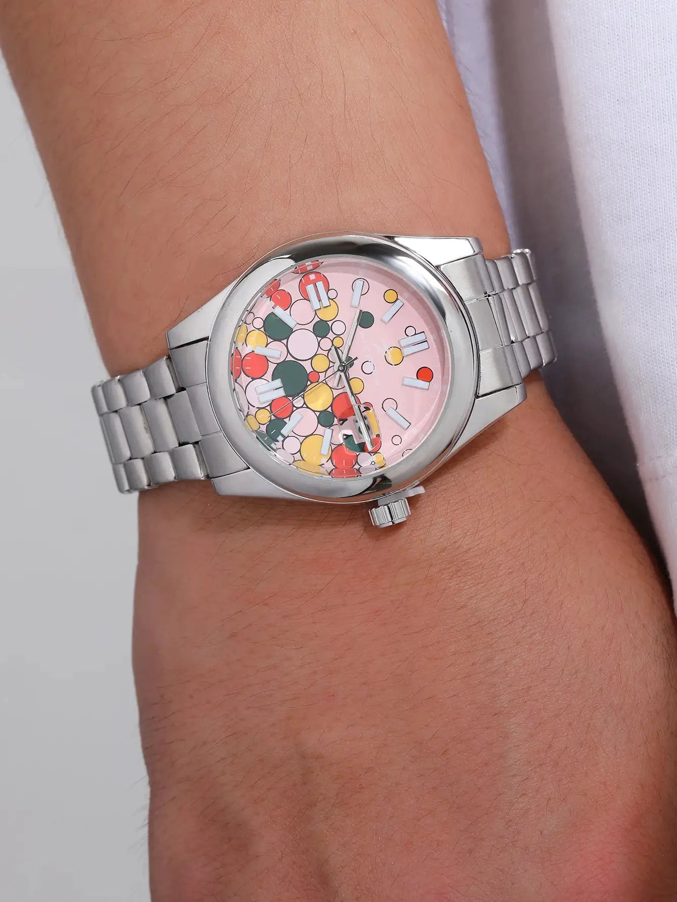 Watch by Simples Market with pink patterned dial and stainless steel bracelet.