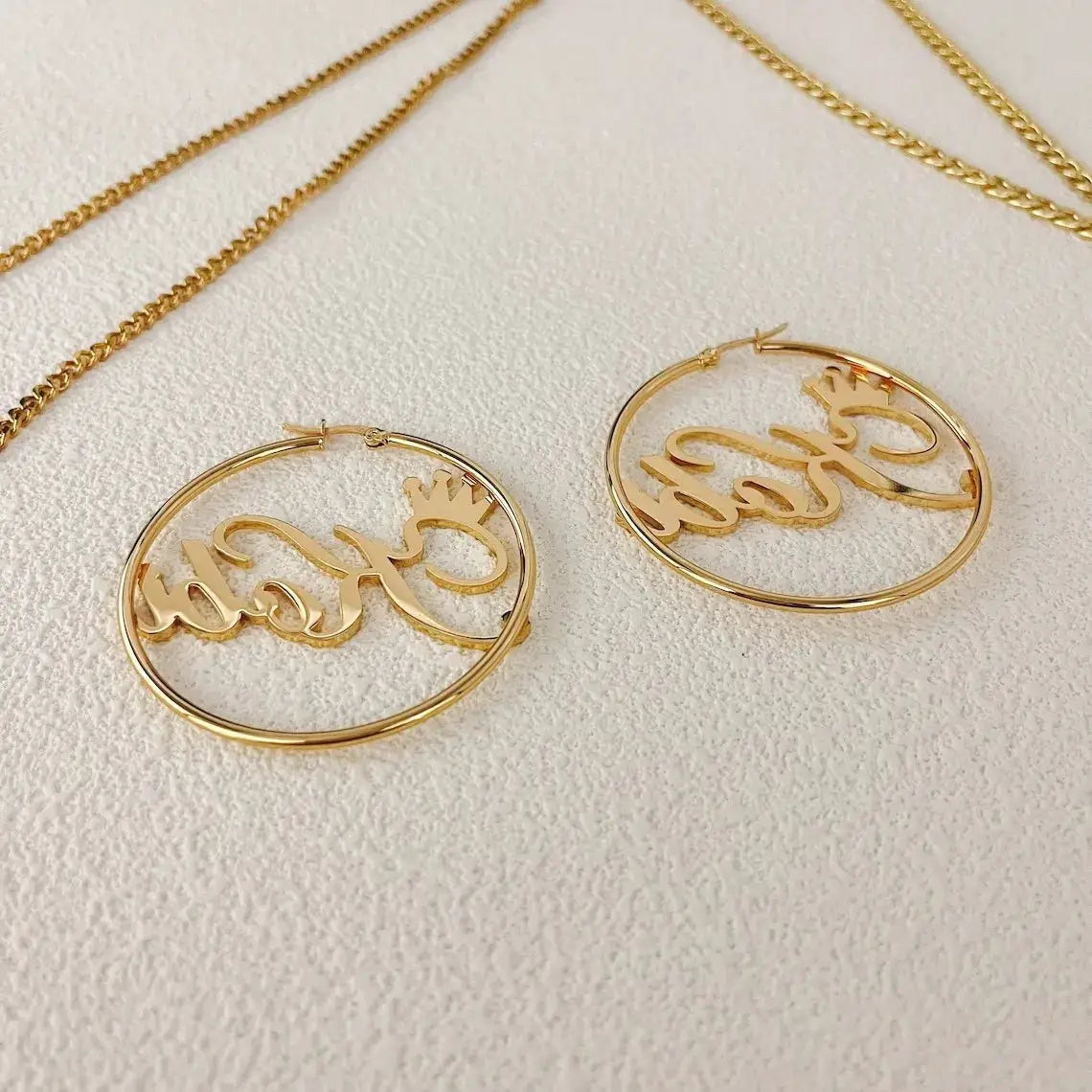 Pair of gold-tone custom crown name hoop earrings with inner scripted name and crown motif