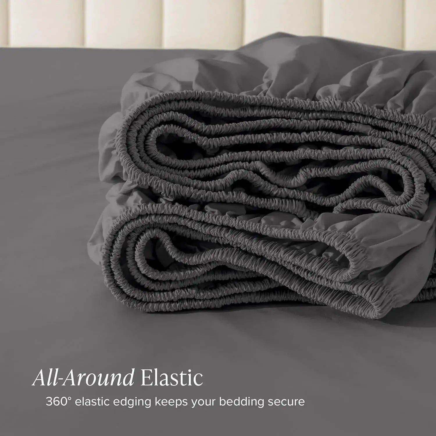Gray cotton fitted sheet with 30cm deep pocket and all-around elastic, folded in a stack.