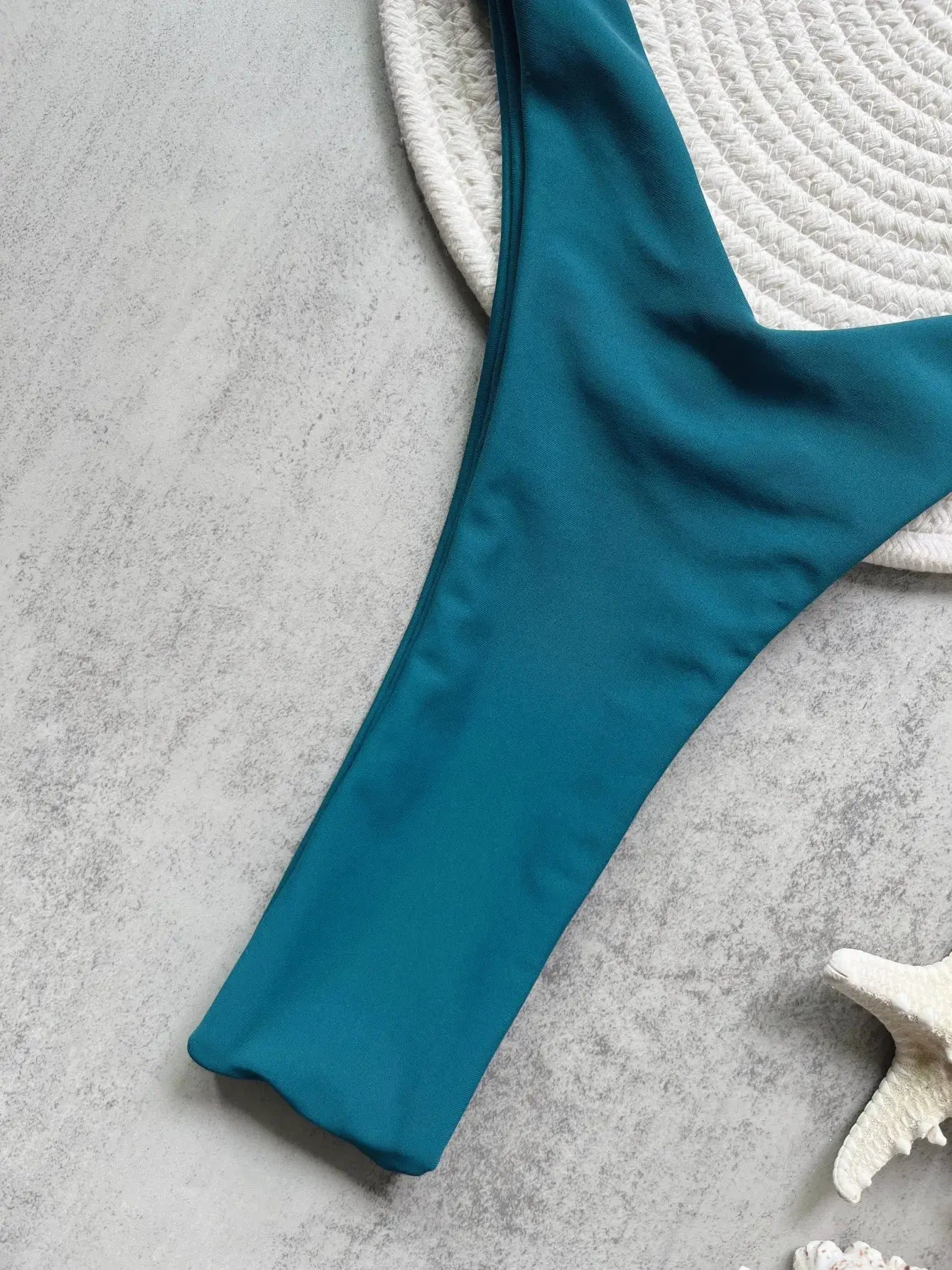 Teal micro bikini bottom with high-cut sides and thong style for beachwear