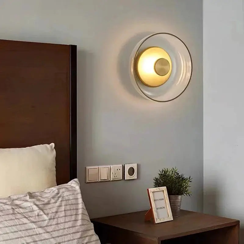 Simples Market Nordic LED glass wall sconce, circular clear glass with warm glow above bedside table.
