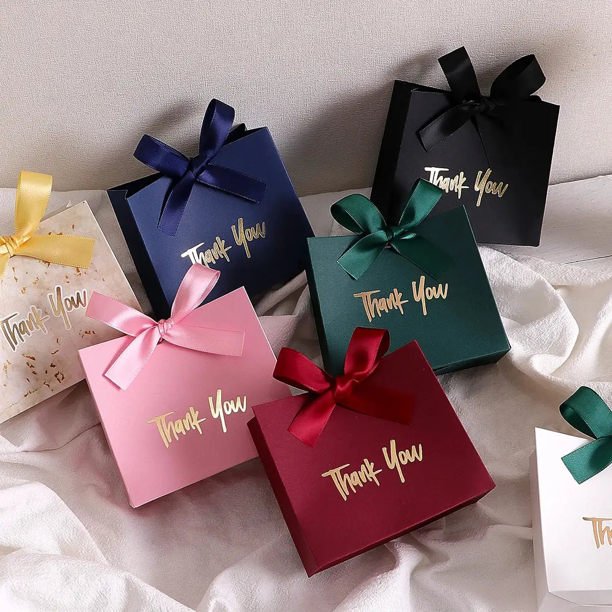 Ten mini gift boxes by Simples Market in assorted colors with gold Thank You text and satin ribbons.