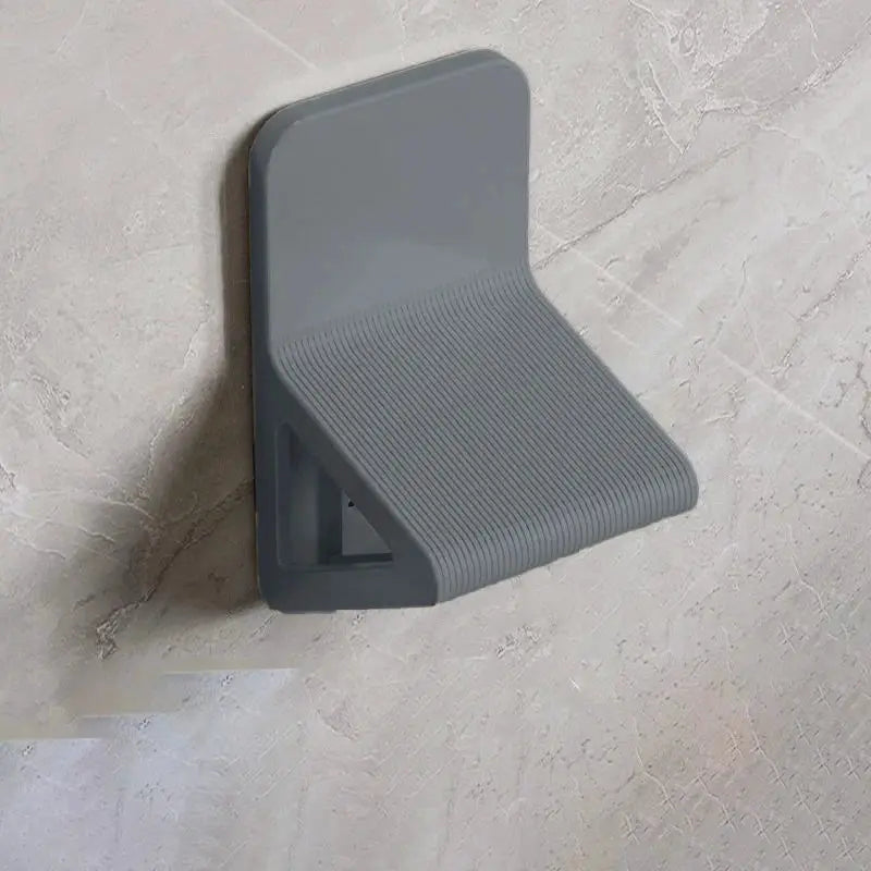 Wall-mounted gray footstool by Simples Market with ribbed surface for foot massage