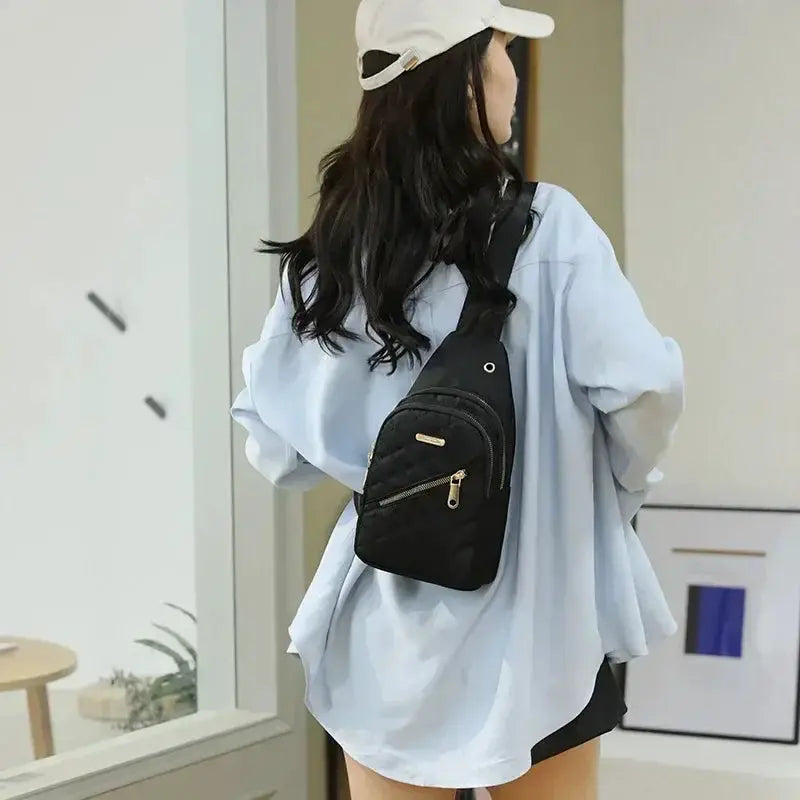 Ladies black quilted crossbody backpack by Simples Market with gold zipper and front pocket.