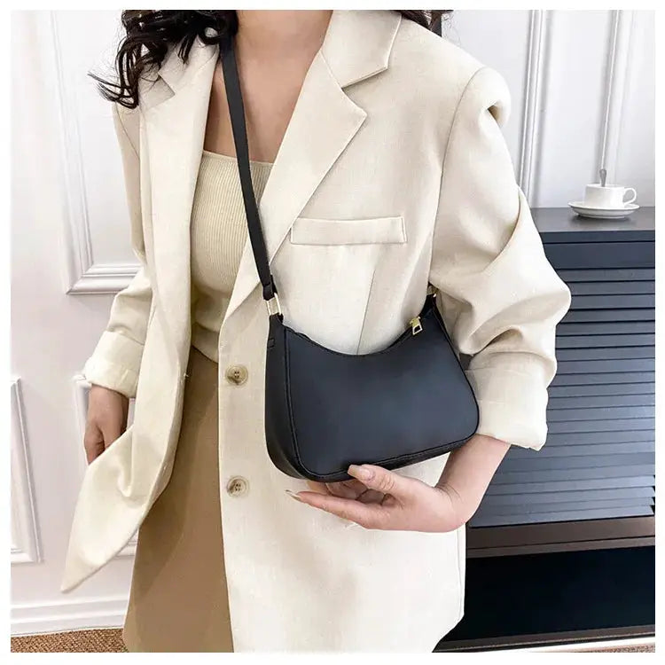Crossbody handbag in black with a compact square shape and single-shoulder strap.