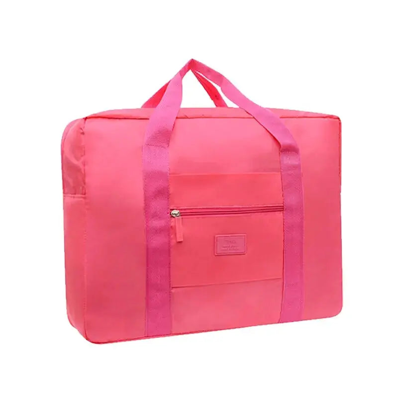 Foldable travel duffel bag in pink nylon with front zip pocket and twin carry handles