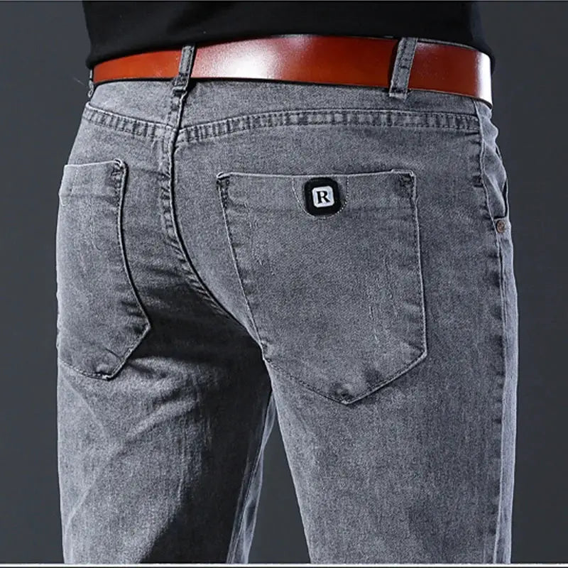 Men's slim-fit gray denim jeans by Simples Market, back pocket with R logo patch and brown belt