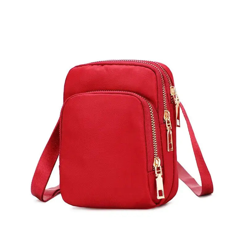 Women's red crossbody bag with dual gold-zipper pockets and an adjustable strap