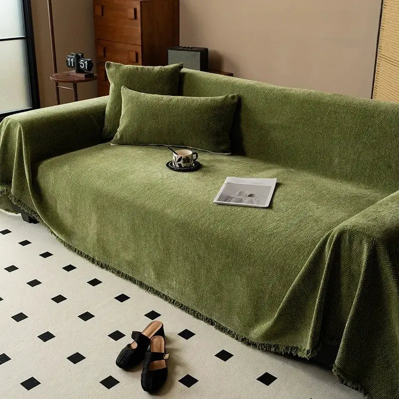 Minimalist chenille sofa cover with tassel edge in olive green on a sofa