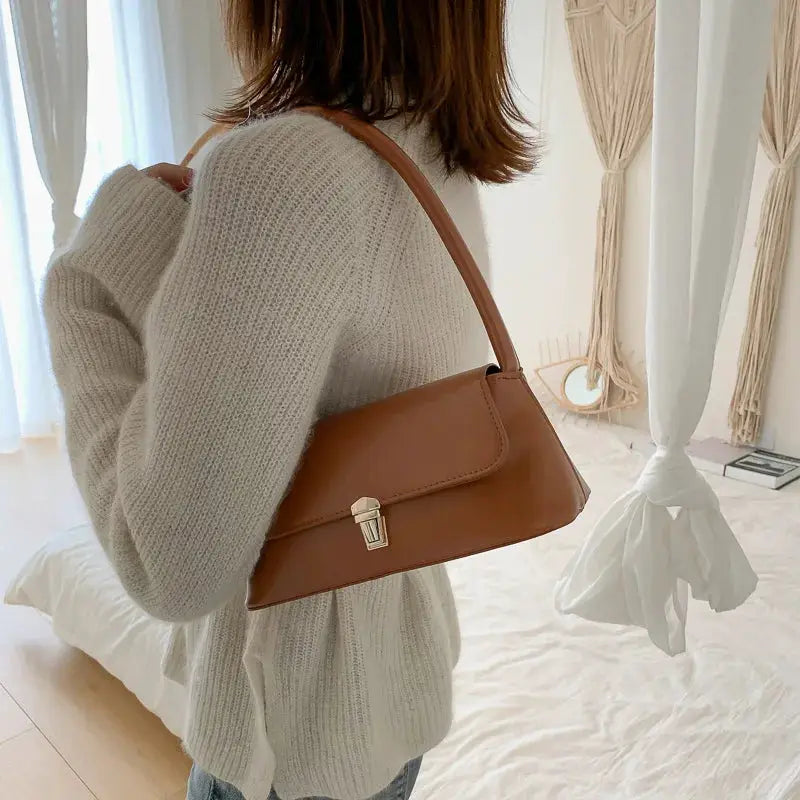 Tan brown leather-look shoulder bag with a front metal turn-lock clasp.