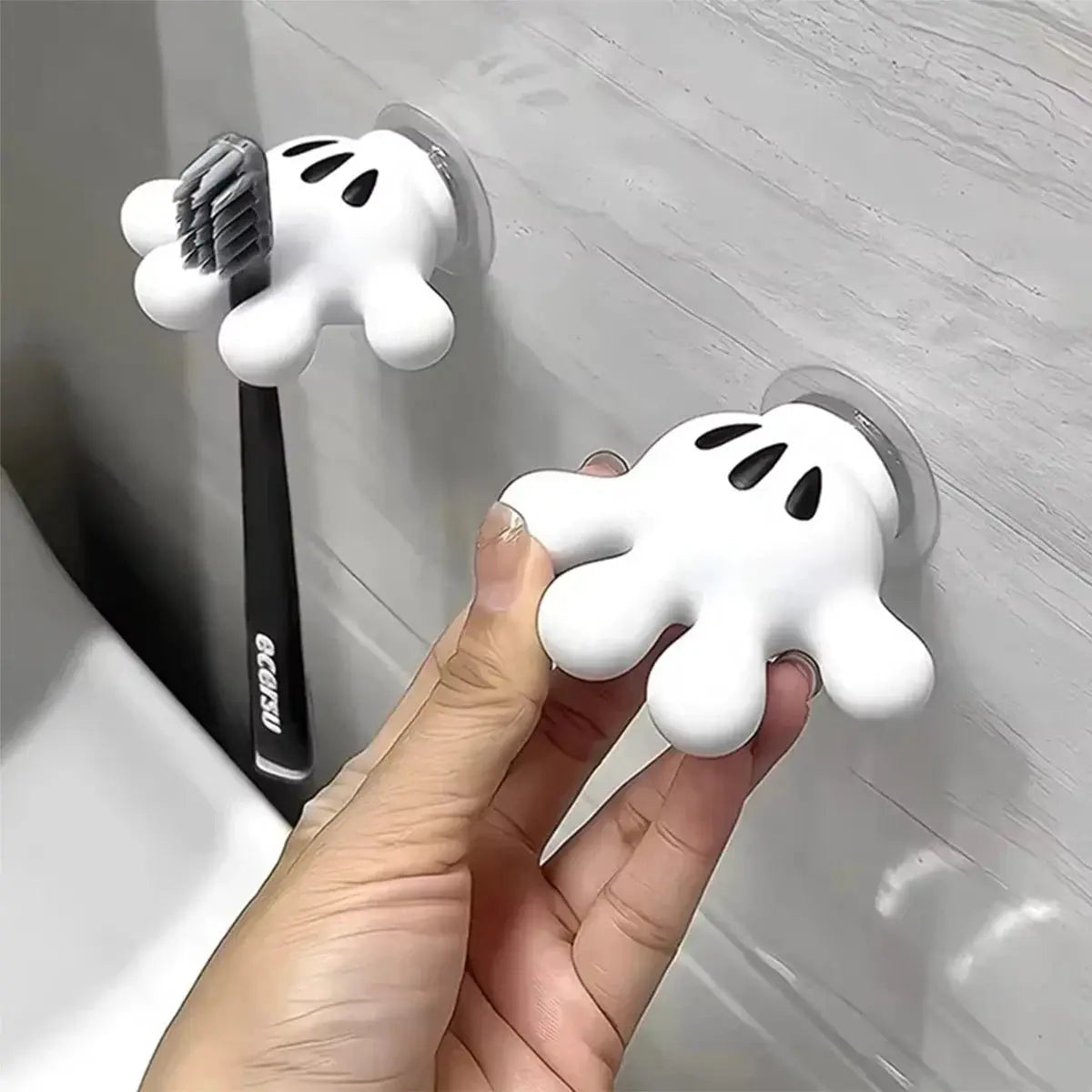 Pair of white Mickey Palm toothbrush holders with suction cups; towel hook and cable winder.