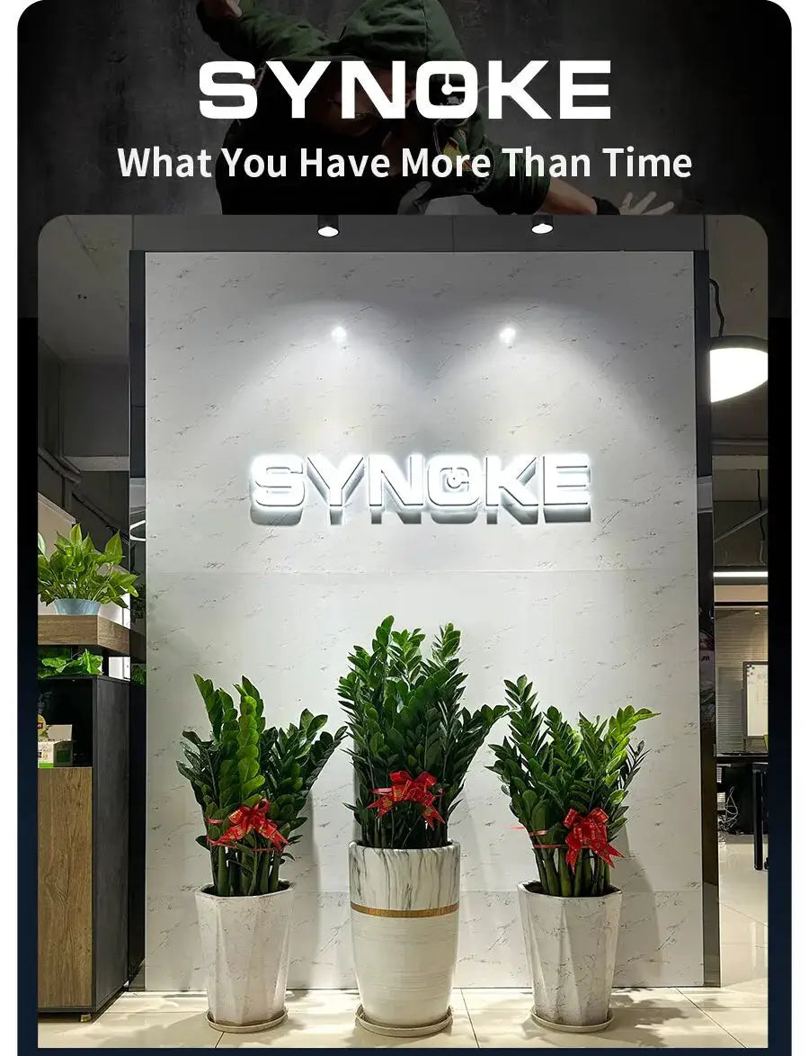 SYNOKE brand logo sign on a marble wall showroom with three potted plants and red ribbons