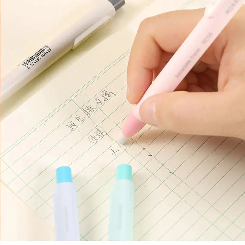 Simples Market press eraser pen with replaceable core, pink retractable eraser in use beside two pastel erasers.