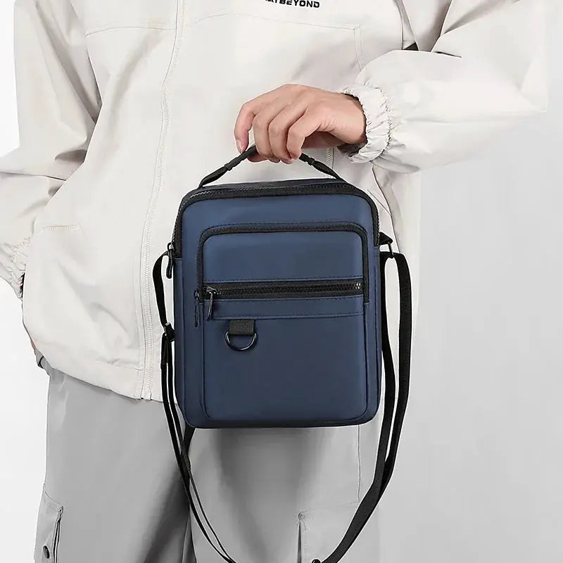 Navy blue messenger sling bag with front zip pocket, D-ring, and adjustable crossbody strap