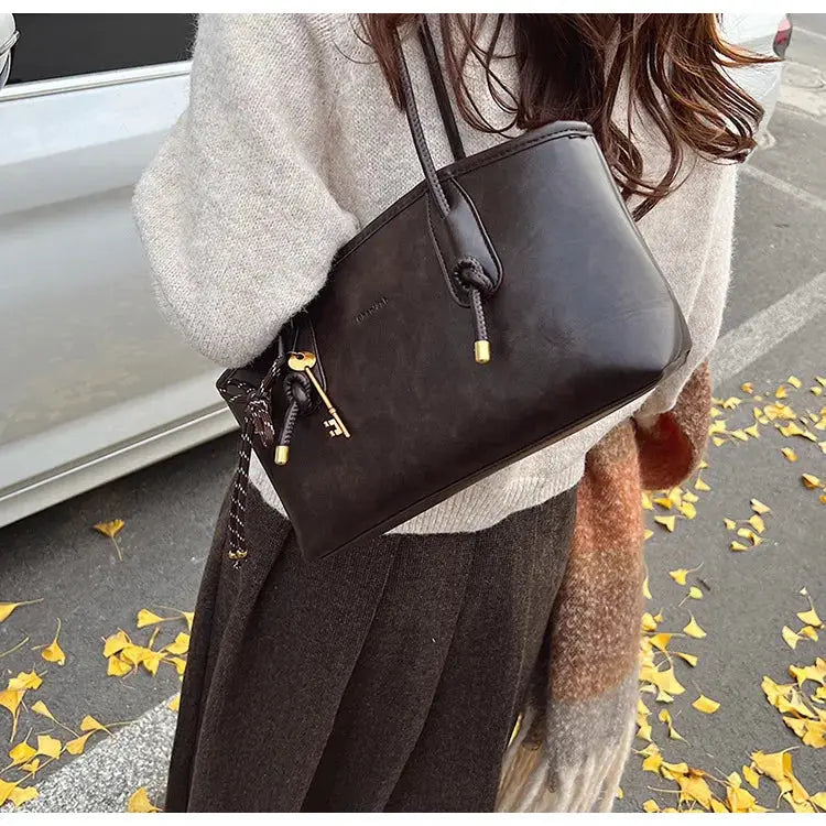 PU leather shoulder bag for women, black top-handle design with gold-tone hardware and decorative key charm