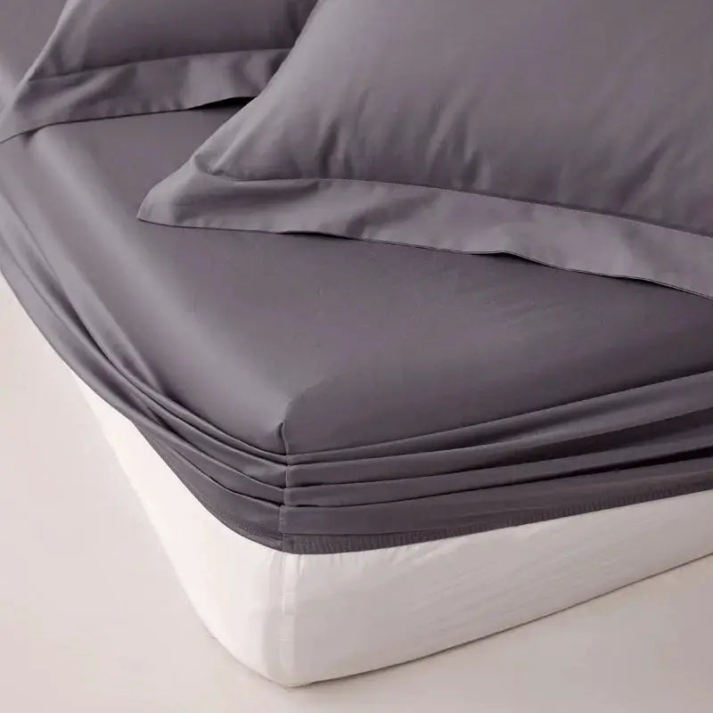 Gray Egyptian cotton fitted sheet with elastic edge on a mattress.