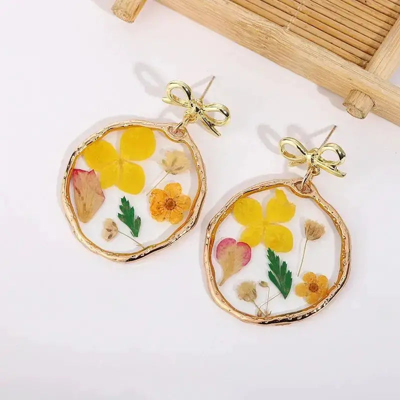 Natural flower dangle earrings with colorful pressed flowers in clear epoxy resin, gold-tone hoops, pair.