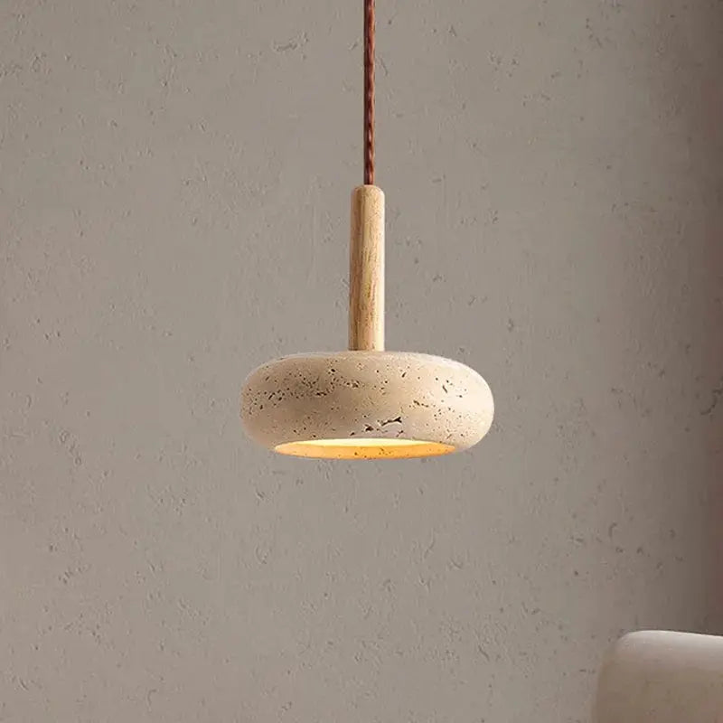Stone circular LED pendant lamp with warm yellow glow, hung by brown cord.
