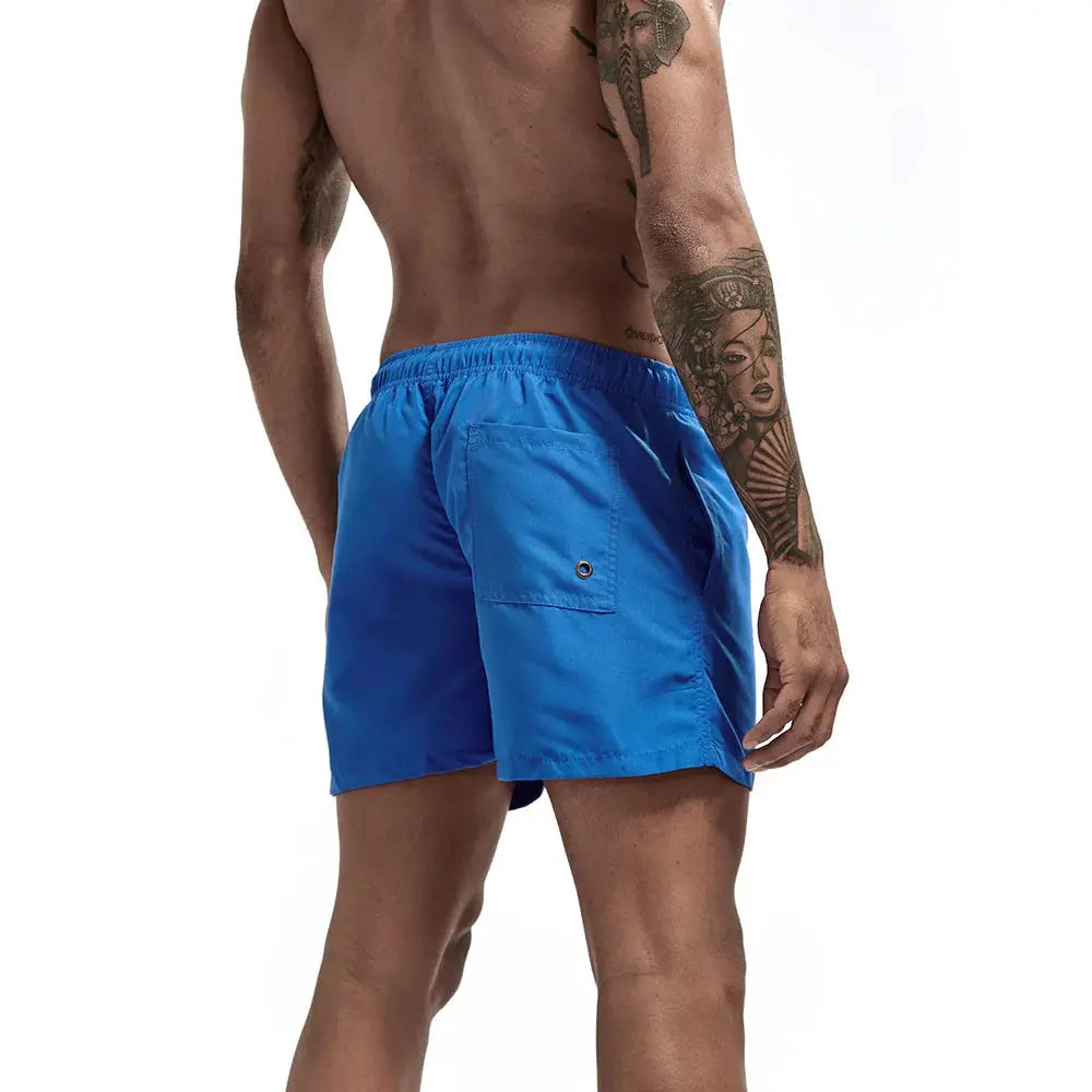 Blue men's swim trunks with elastic waistband and back pocket; quick-dry board shorts