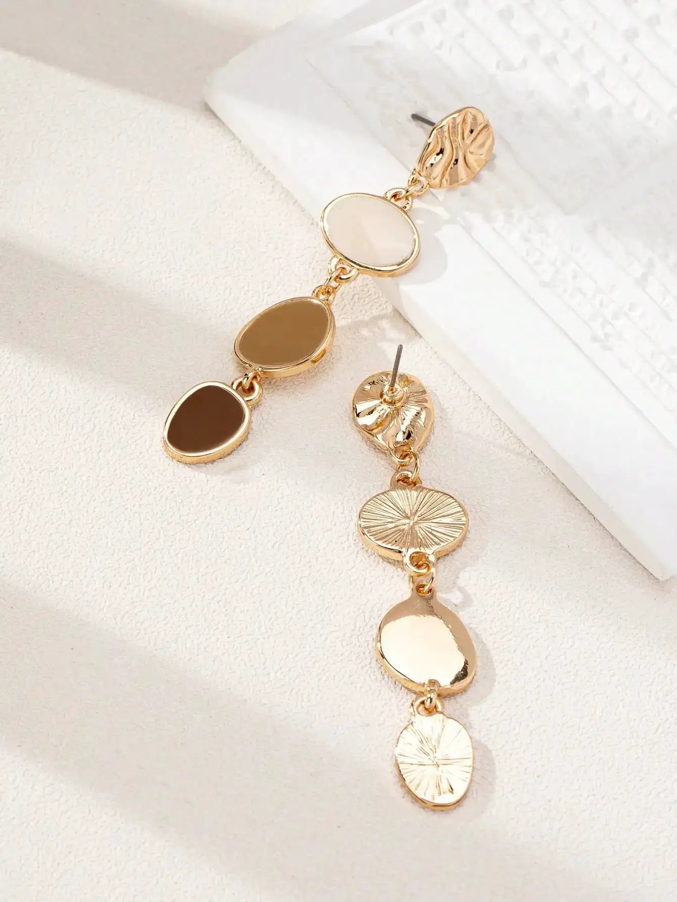 Gold-tone drop earrings with cream and brown oval stones and textured round discs