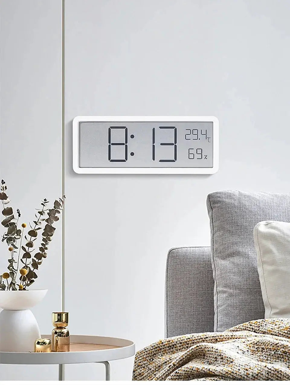 LCD digital wall clock by Simples Market with white plastic frame showing time, 29.4°C and 69% humidity.