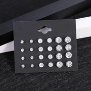 12-pair clear crystal stud earrings set in varying sizes on a black display card