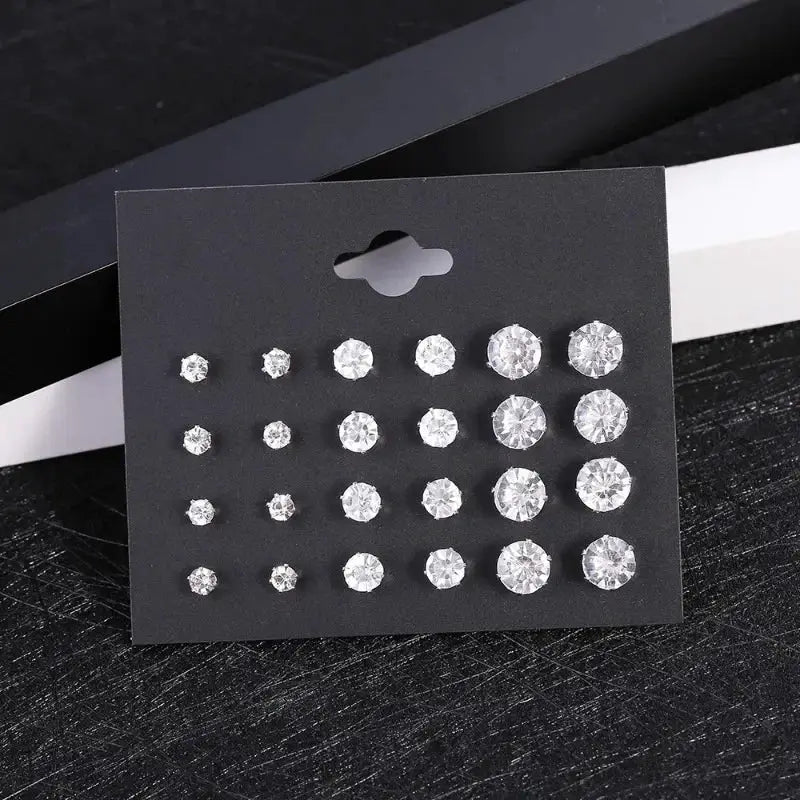 12-pair clear crystal stud earrings set in varying sizes on a black display card