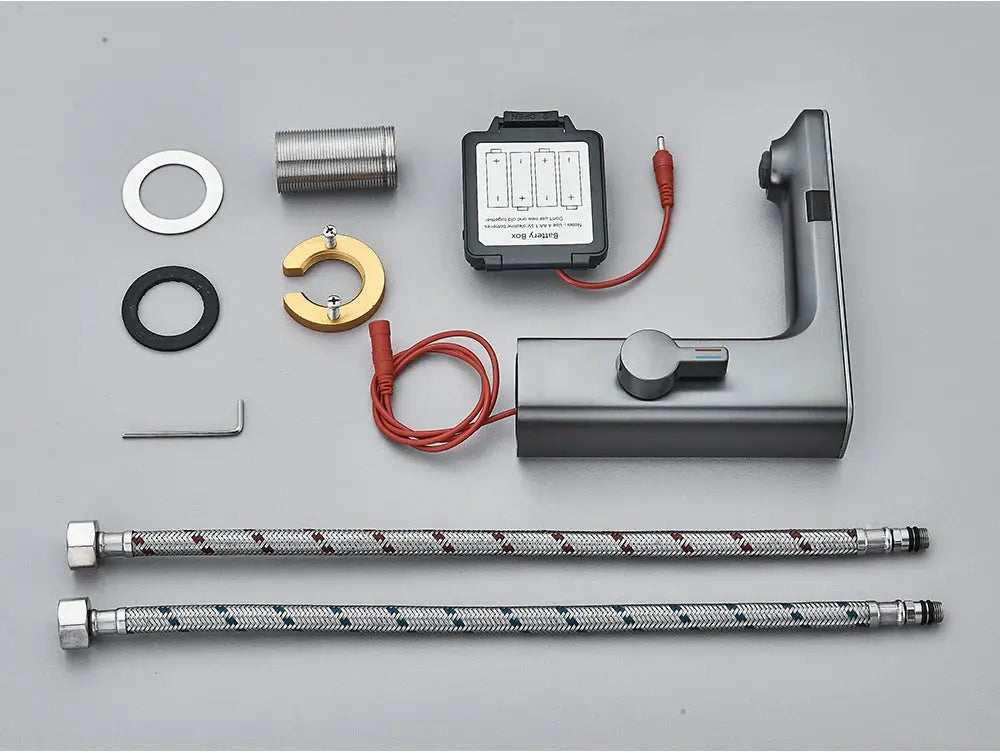 Gray metal smart sensor basin faucet with digital display controller and two braided supply hoses.
