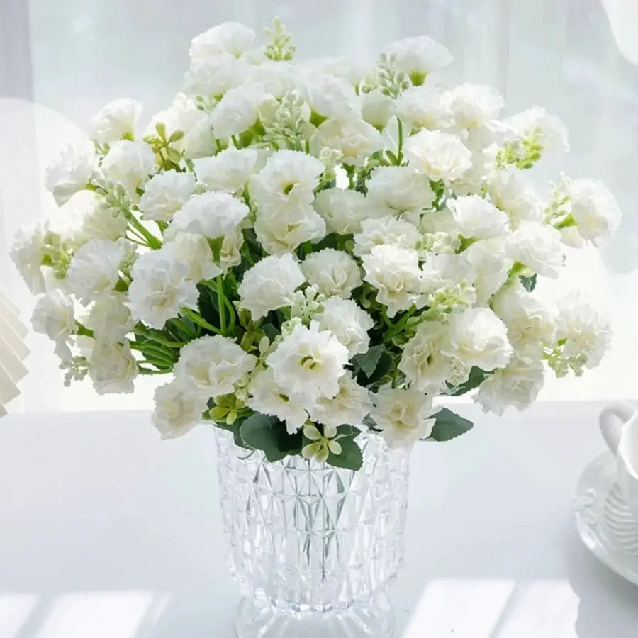 White carnation bouquet with 15 blooms in a clear crystal-cut glass vase