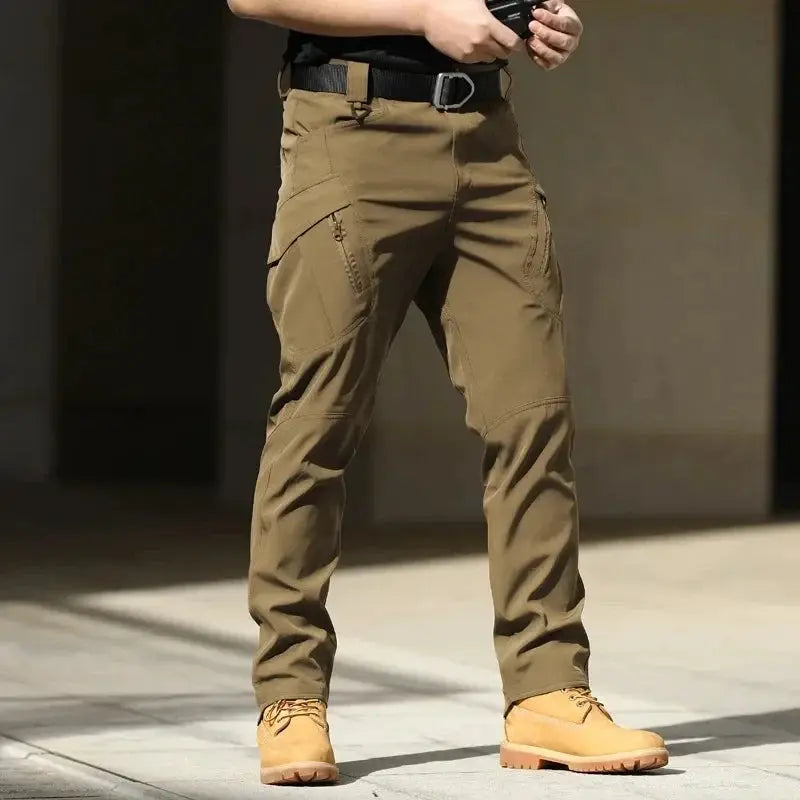 Men's Tactical Cargo Pants in khaki; softshell, stretchy fabric with multiple pockets and button fly.