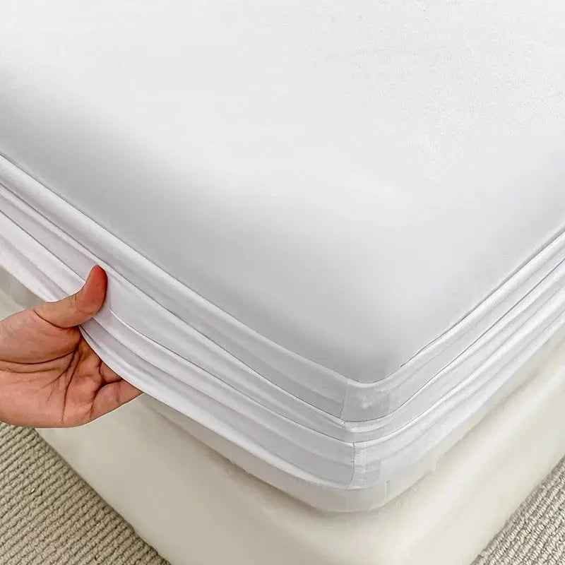 Fitted white bed sheet with elastic band for mattress, showing secure corner edge on bed