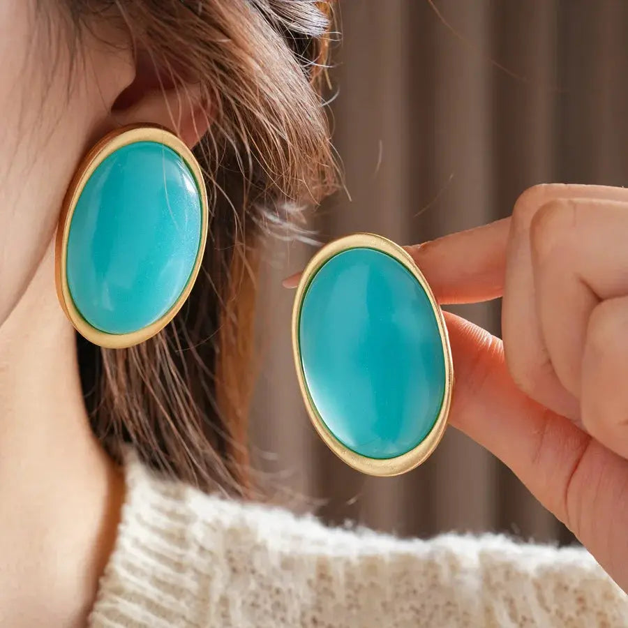 Pair of teal oval resin earrings with gold-tone bezel