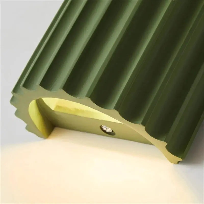 Nordic modern resin wall lamp in olive green with a ribbed shade for bedroom or living room decor.