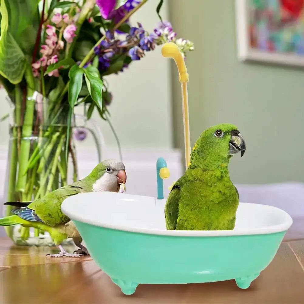 Parrot plastic bird bath tub in blue with shower head attachment; two green parrots using it.