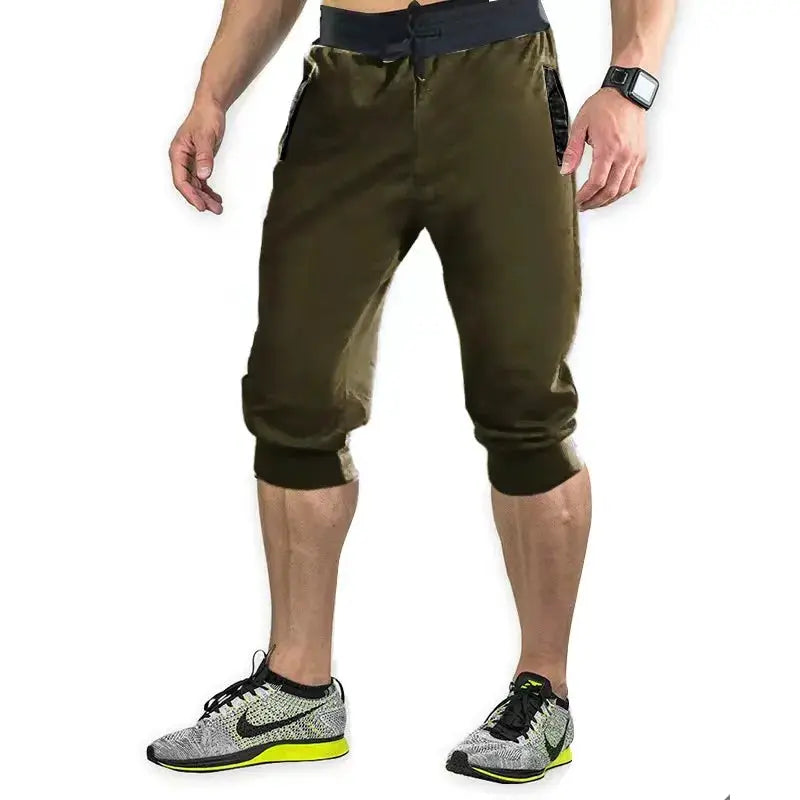 Men's olive green athletic capri jogger pants with black cuffs and zip pockets