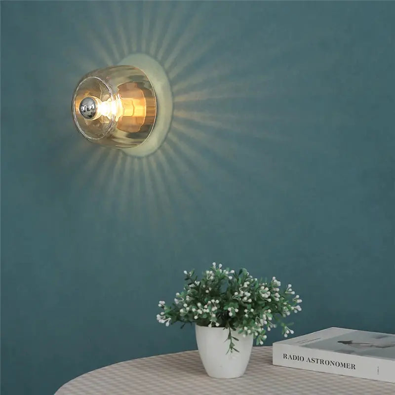 LED glass wall lamp with clear round shade, warm glow.