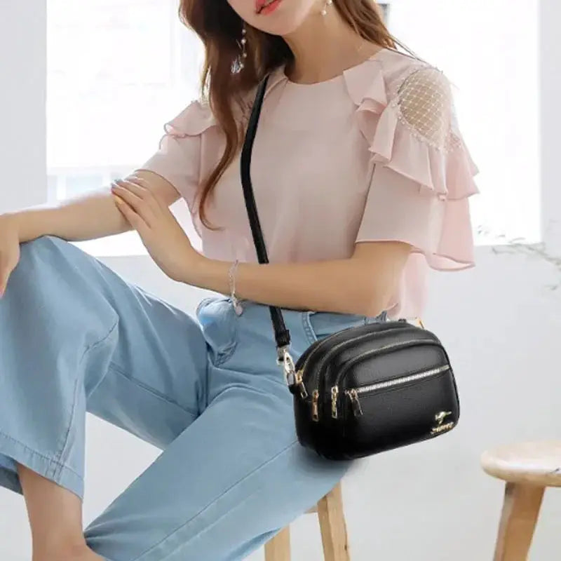 Leather crossbody purse by Simples Market, black soft leather with multiple zip pockets and gold hardware