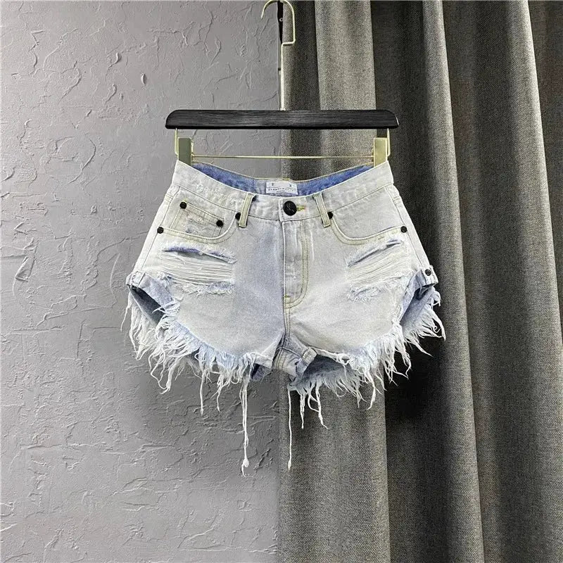 Women's denim shorts by Simples Market with light wash, frayed edges and distressed patches