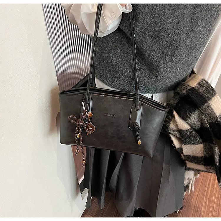 Simples Market PU leather shoulder bag for women in dark brown with tassel charm