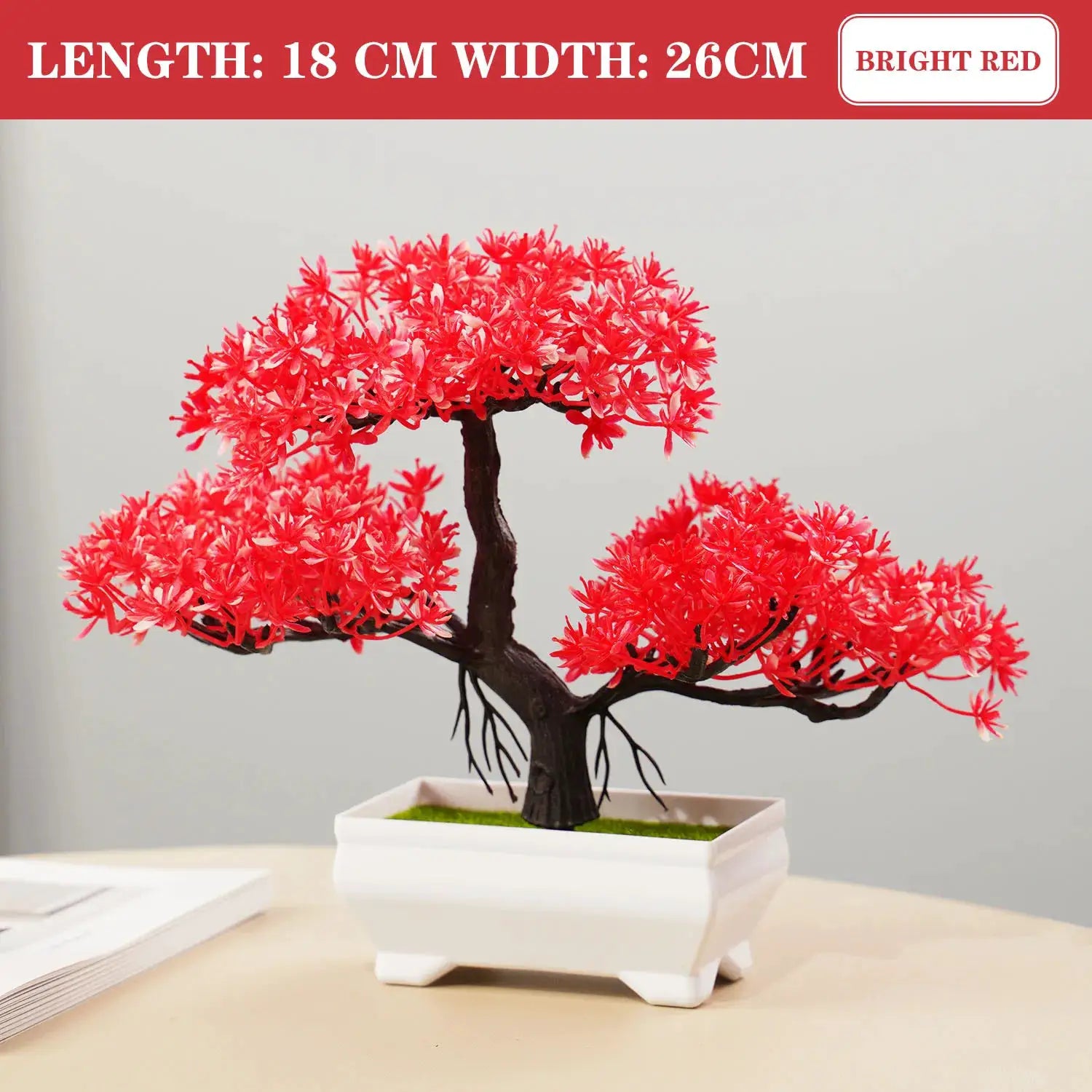 Artificial bonsai tree in a white rectangular pot with bright red foliage and moss on top, tabletop decor.