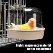 Hanging bird bath cube with clear dome and white basin, yellow lovebird inside.