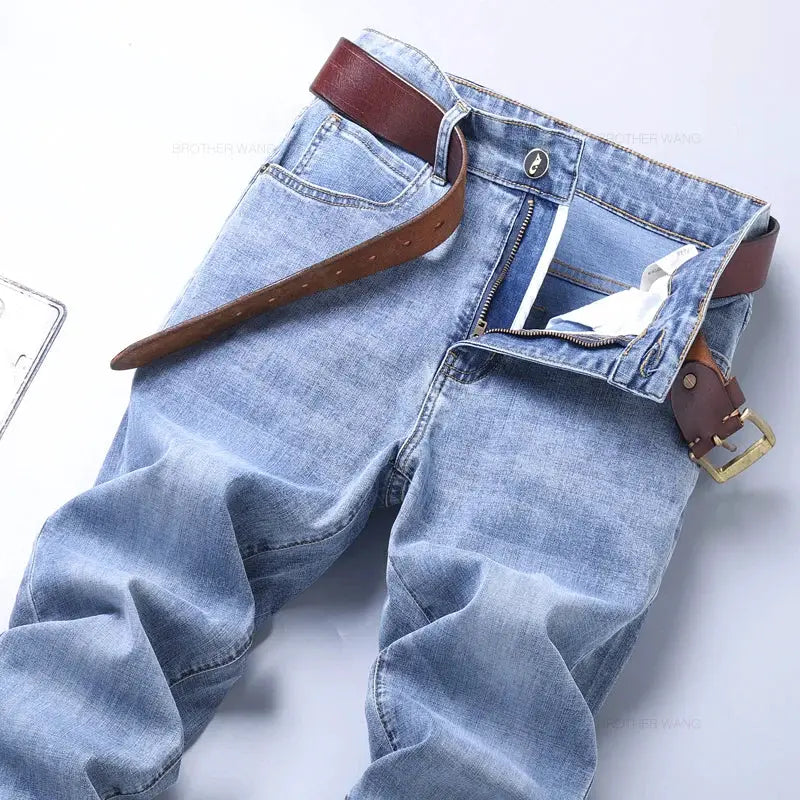Men's light blue slim-fit denim jeans with brown belt and zipper fly