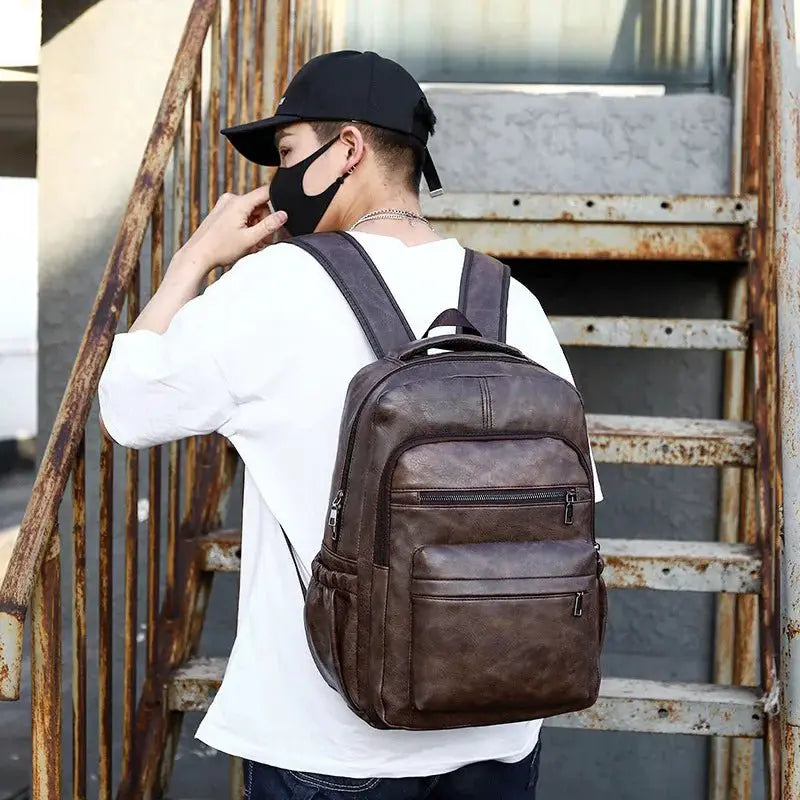 Model wearing a USB charging PU leather backpack while climbing stairs, showcasing its stylish design and functionality.