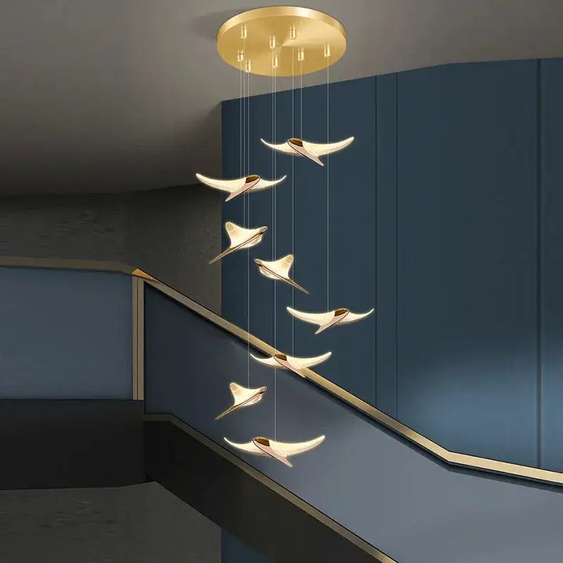 Seagull staircase pendant lamp by Simples Market in gold finish, cascading modern design along blue staircase.
