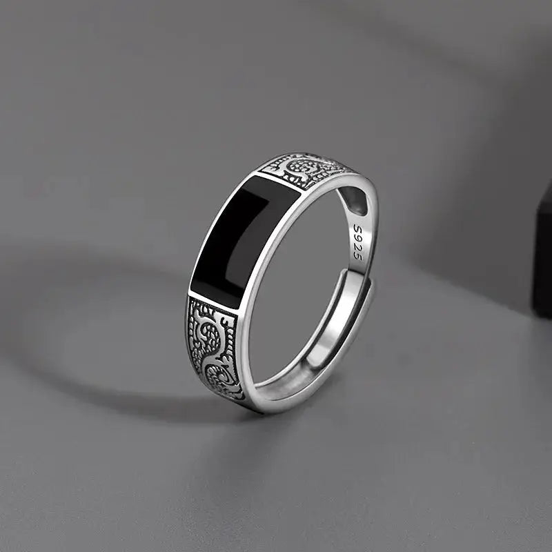 Sterling silver men's ring with black inlay and ornate engraved side panels