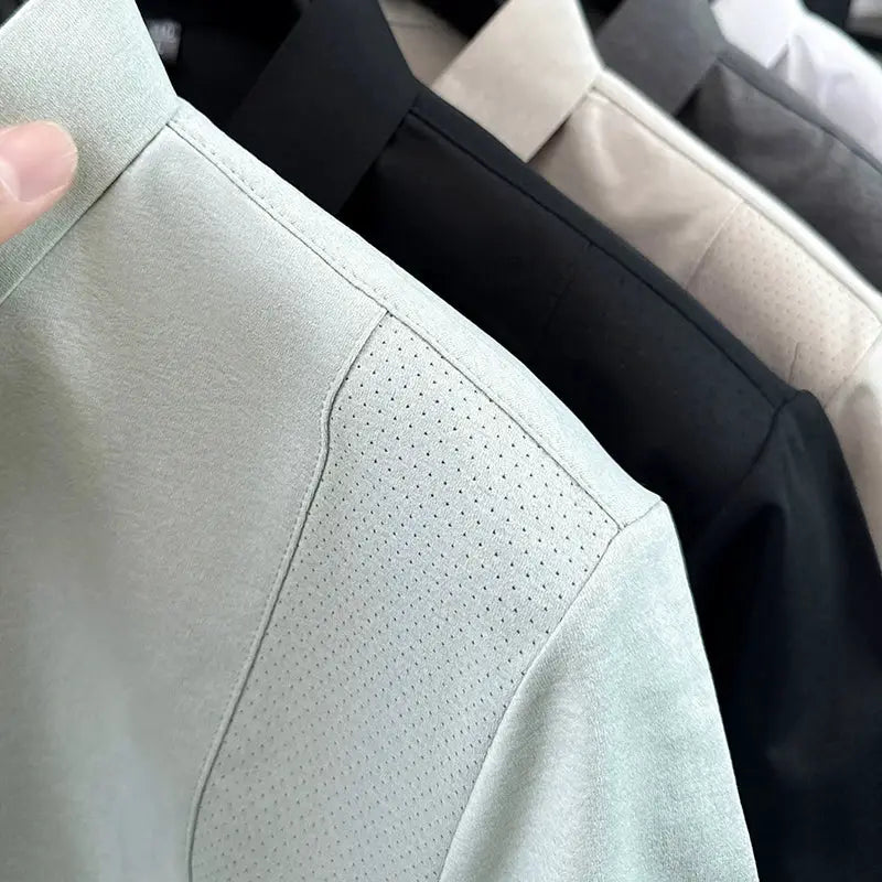 Men's polo shirts set in mint green with perforated shoulder panel; black, beige, gray and white variants on hangers