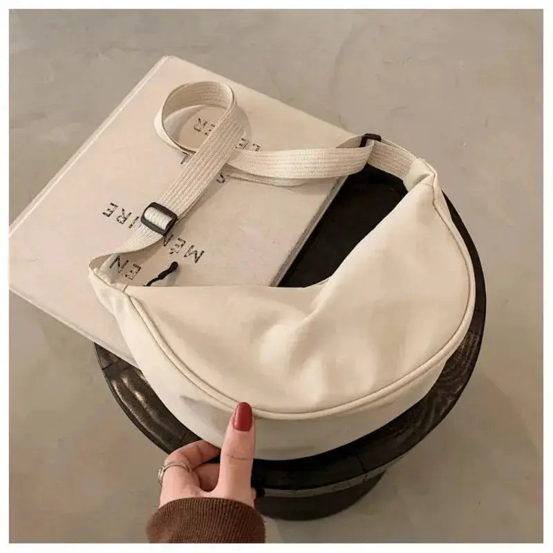 Nylon dumpling bag in white, lightweight crossbody with adjustable cream strap by Simples Market