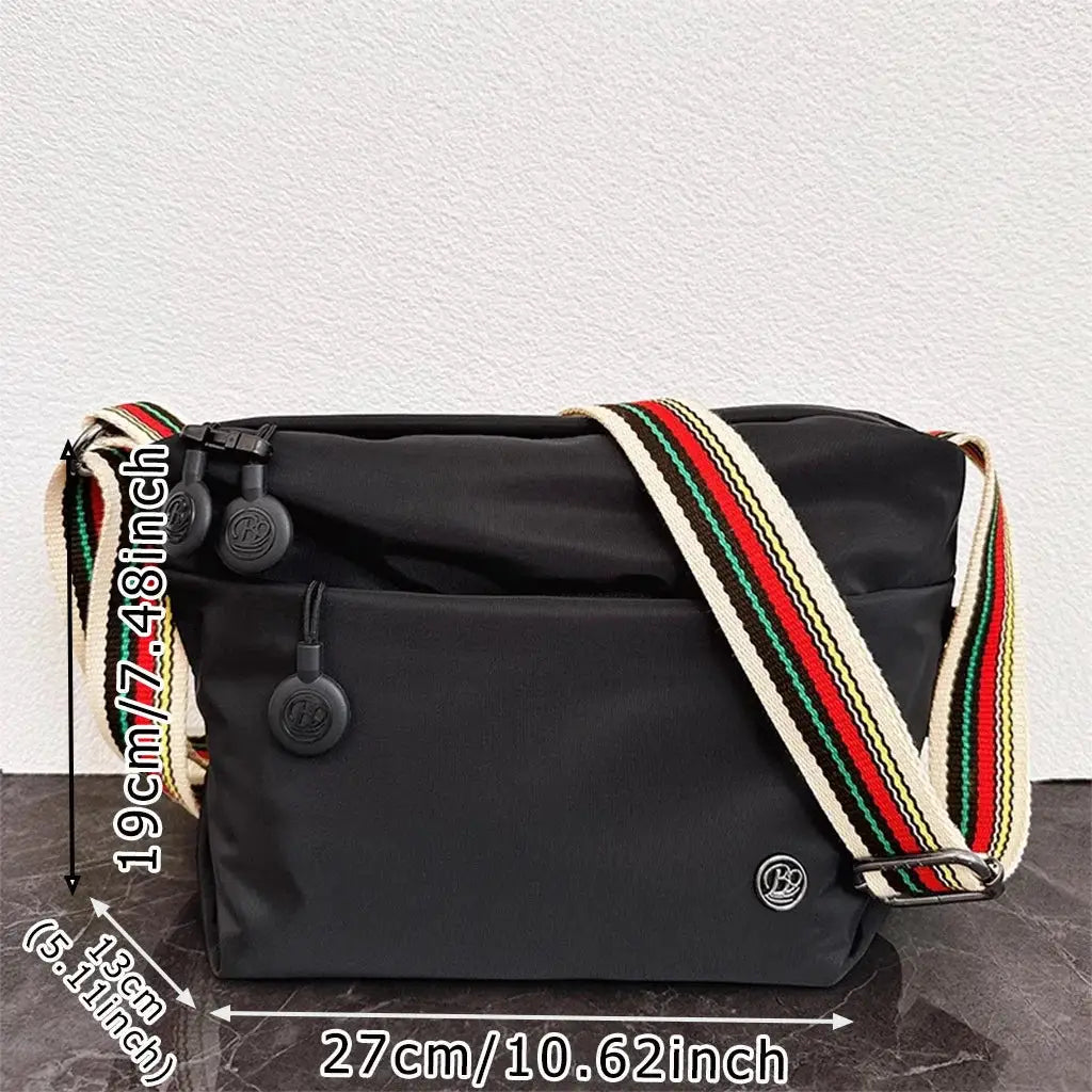 Ultra-light nylon crossbody bag in black with zipper closure and adjustable wide striped strap by Simples Market