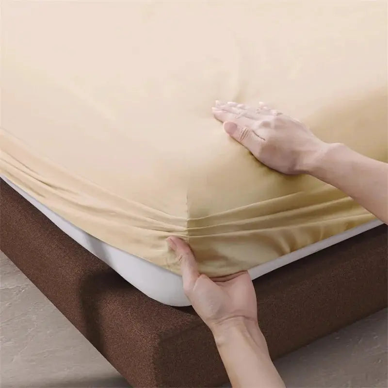 Simples Market Egyptian cotton fitted sheet in beige, ultra-soft 800TC, being pulled over a mattress.